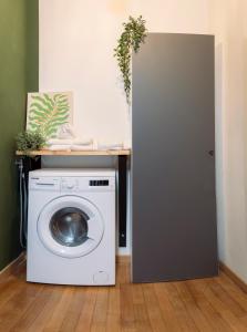 una lavatrice in una lavanderia con tavolo di Treviso City Center BnB - Comodo per Stazione e Centro Città a Treviso