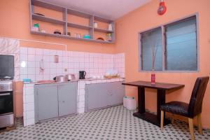 een keuken met een tafel, een tafel en een stoel bij Crystal Home in Douala