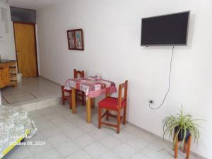 a room with a table and chairs and a television at Depto Ideal in Deán Funes