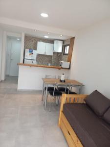 a room with a kitchen and a table and a bed at Depto 41 in Santa Teresita