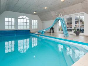 a swimming pool with a blue slide in a building at 4 star holiday home in Ulfborg in Ulfborg