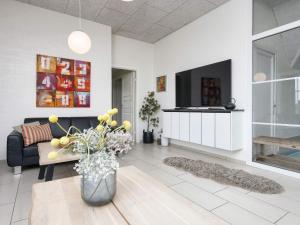 a living room with a couch and a tv at Luxury Retreat with Pool in Ulfborg