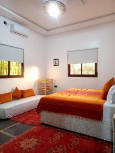 a bedroom with two beds and two windows at فيلا رياض عمران in Douar Blidene