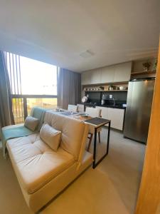 een woonkamer met een witte bank en een keuken bij sol flat cabo branco 50 metros do mar in João Pessoa