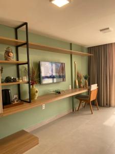 een woonkamer met een bureau en een stoel bij sol flat cabo branco 50 metros do mar in João Pessoa