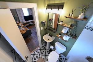 Un baño con un inodoro blanco y un lavabo. en Charming Benson Home - Sleeps 5 Hot Tub!, en Omaha