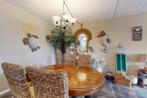 a dining room with a wooden table and rattan chairs at Beachview Condominiums #111 in South Padre Island