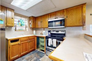a kitchen with wooden cabinets and a stove at Beachview Condominiums #111 in South Padre Island +17 photos