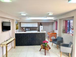 a living room with a kitchen and a table at Hotel Savana in Olímpia