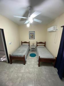 a room with two beds and a ceiling fan at Duplex Monte Caseros in Monte Caseros