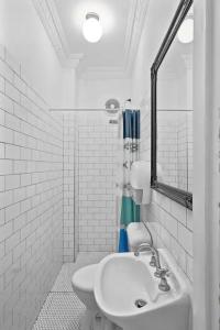 a white bathroom with a sink and a toilet at The Pyrmont Budget Hotel in Sydney