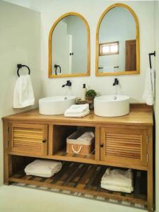 a bathroom with two sinks and two mirrors at Villa Blanca Frances in San Silvestre