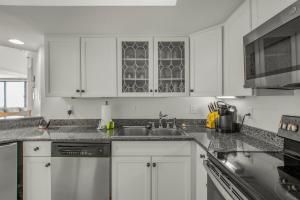 a kitchen with white cabinets and a sink at Summer House 103A by Vacation Homes Collection in Orange Beach +61 photos
