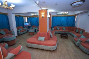 a waiting room with red couches and blue curtains at Tiba Hotel in Aswan