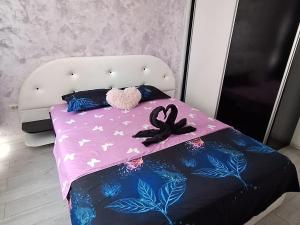 a pink bed with a stuffed animal on top of it at Daniel Residence Militari in Dudu +23 photos