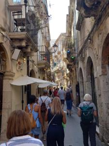 a group of people walking down a narrow street at Chez Dione in Siracusa