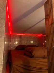 a bedroom with a bed with a red light at Beau-voisin 2 in Rouen +3 photos
