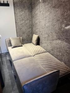 a large bed in a room with a wall at Beau-voisin 2 in Rouen