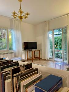 un soggiorno con una pila di libri e una TV di Villa Salina - Vicina al mare con giardino privato a Trabia