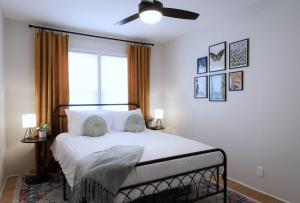 a bedroom with a bed with a fan and a window at Vintage Modern Mid-Century Gem in Omaha