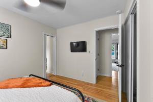 a bedroom with a bed and a tv on the wall at Vintage Modern Mid-Century Gem in Omaha