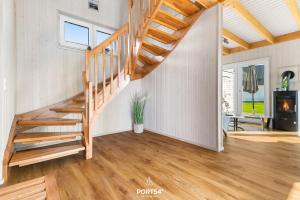 een trap in een woonkamer met houten vloeren bij Ferienhaus Krabbenkaddy Olpenitz in Kappeln
