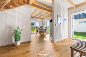 een woonkamer met een houten vloer en een tafel bij Ferienhaus Krabbenkaddy Olpenitz in Kappeln