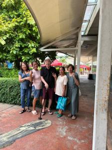 eine Gruppe von Menschen, die unter einem Gebäude für ein Foto posieren in der Unterkunft En Pensionne Pension House in Iloilo City