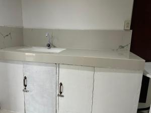 eine weiße Arbeitsplatte mit einem Waschbecken in einem Zimmer in der Unterkunft En Pensionne Pension House in Iloilo City + 4 Fotos