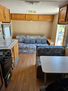 an rv kitchen and living room with a couch at Comanche Teepee at Nomad Landing in Clayton