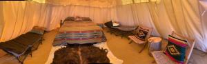 a bedroom with a bed in a tent with chairs at Comanche Teepee at Nomad Landing in Clayton