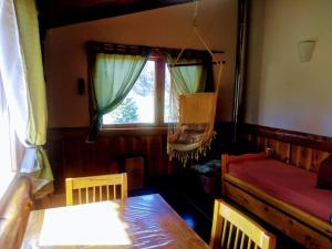 a room with a bed and a table and a window at Cabañas SurEnya in El Bolsón