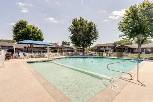 a large swimming pool with chairs and umbrellas at Waterfront Lazy Days Condo with Views and Pool Access! in Osage Beach