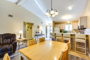 a living room with a table and a kitchen at Waterfront Lazy Days Condo with Views and Pool Access! in Osage Beach