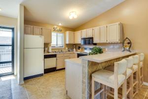 a kitchen with a white refrigerator and a counter at Waterfront Lazy Days Condo with Views and Pool Access! in Osage Beach