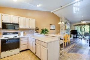 a kitchen with white cabinets and a dining room at Waterfront Lazy Days Condo with Views and Pool Access! in Osage Beach