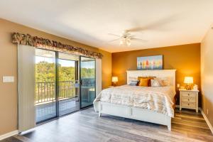a bedroom with a bed and a balcony at Waterfront Lazy Days Condo with Views and Pool Access! in Osage Beach