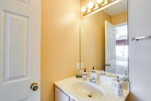 a bathroom with a sink and a mirror at Waterfront Lazy Days Condo with Views and Pool Access! in Osage Beach