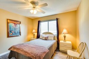 a bedroom with a bed with a ceiling fan and a window at Waterfront Lazy Days Condo with Views and Pool Access! in Osage Beach +25 photos
