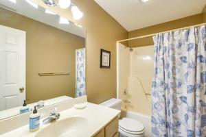 a bathroom with a sink and a toilet and a mirror at Waterfront Lazy Days Condo with Views and Pool Access! in Osage Beach
