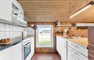 a kitchen with white cabinets and a window at Pet Friendly Home In Thisted With Sauna in Thisted