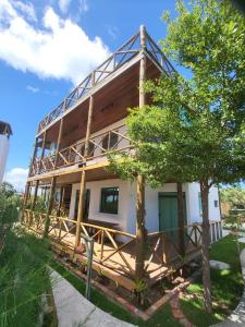 a house with a balcony on the side of it at Chale Praia Barrinha in Barrinha
