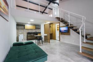 a room with a green bed and a staircase at LOFTS GREEN ISLAND in Abraão
