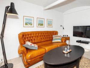 a leather couch in a living room with a table at Charming Farmhouse Retreat - By Traum Ferienwohnungen in Frederikshavn