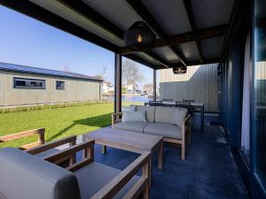 a patio with couches and a table and chairs at Waterfront Stay w Pets in Delfstrahuizen