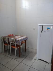 a small kitchen with a table and a refrigerator at Espaço coração de mãe in Pirapòzinho