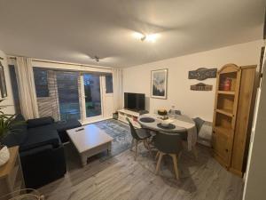 a living room with a couch and a table with chairs at 2 bed room , ensuite Flat close to Heathrow, Windsor , Langley in Langley Marish