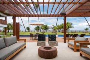 un patio con tavolo e sedie e una piscina di Village do Mar Itacimirim pé na areia a Camassari