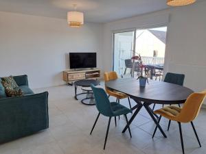 a living room with a table and chairs and a television at Apartment in Finistère with Free E-Bike in Plouarzel