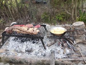 a grill with some meat and a bowl of chips at Isla Curubica Premium in Tigre